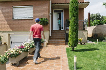 Woman waiting for postal worker to deliver her package - XLGF00193