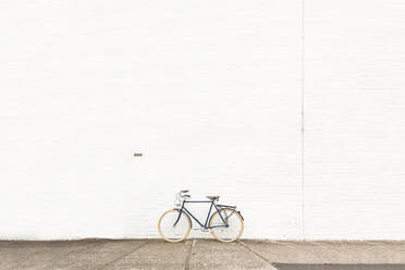 Bicycle On Street Against White Wall - EYF05735