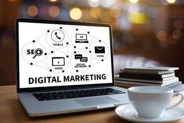 Laptop Displaying Digital Marketing Diagram With Books And Coffee Cup On Table - EYF05778