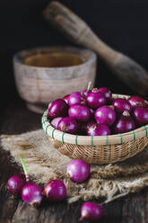 High Angle View of Onions In Weidenkorb mit Burlap auf Holztisch - EYF05821