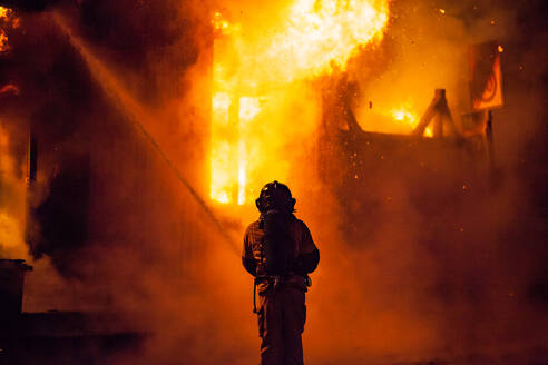 Rückansicht eines Feuerwehrmanns bei Nacht - EYF05826