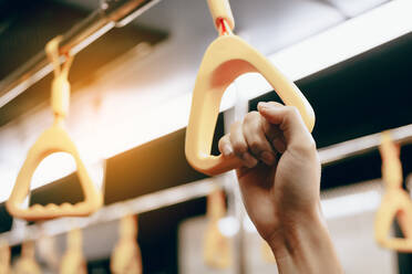 Cropped Hand der Frau hält gelben Griff während der Reise im Zug - EYF05890