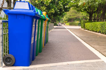 Colorful Garbage Cans Arranged In Row On Footpath At Park - EYF05896