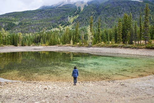 Rückansicht einer Frau, die im Banff National Park steht und die Aussicht betrachtet - CAVF85360