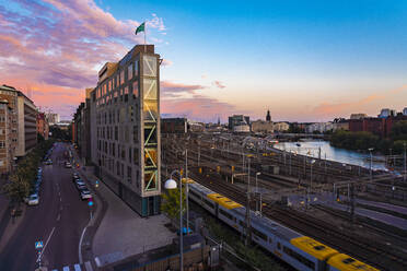 Schweden, Sodermanland, Stockholm, Schmales Gebäude vor den Gleisen des Stockholmer Hauptbahnhofs in der Abenddämmerung - TAMF02275