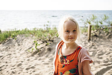 Blondes Mädchen steht am Strand vor der Georgian Bay an einem sonnigen Tag - JVSF00004