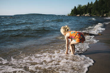 Blondes Mädchen spielt am Ufer des Strandes - JVSF00007