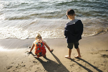 Geschwister, die sich am Strand vergnügen - JVSF00008