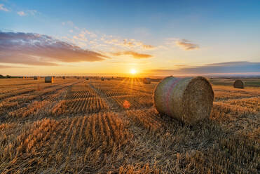 Heuballen auf dem Feld gegen den Himmel bei Sonnenuntergang - EYF05984