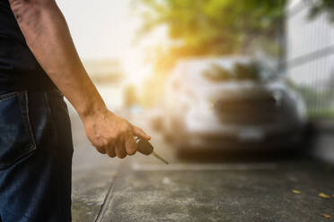 Midsection Of Man Holding Car Key On Footpath - EYF06032