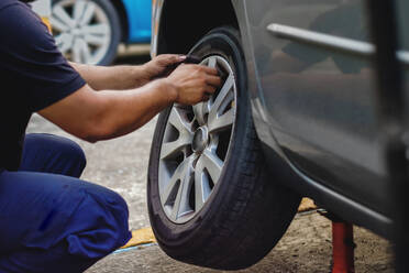 Mechanic Changing Tire Of Car - EYF06075