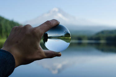 Close-Up Of Human Hand With Reflection Against Sky - EYF06127