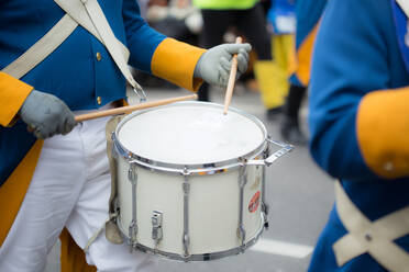 Mittelteil eines Mannes, der während des Karnevals auf der Straße Trommel spielt - EYF06132