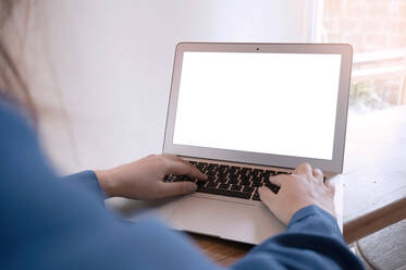 Cropped Hände der Geschäftsfrau mit Laptop am Tisch im Büro - EYF06182