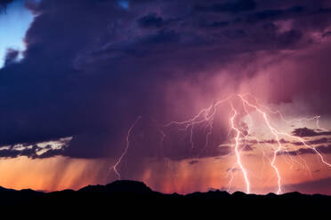 Low Angle View of Lightning Over Silhouette Landschaft in der Abenddämmerung - EYF06194