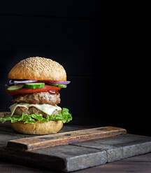 Black burger on stone cutting board Stock Photo by DC_Studio