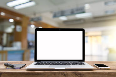 Close-Up Of Laptop With Mobile Phone On Table In Office - EYF06248