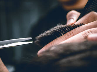 Mittelteil eines Mannes, der beim Friseur die Haare schneidet - EYF06261