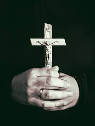 Mittelteil eines Priesters, der ein Kreuz hält - EYF06369