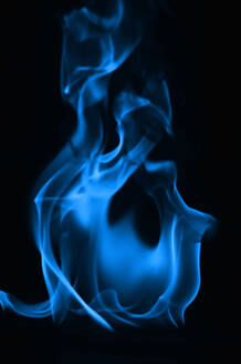 Nahaufnahme einer blauen Flamme vor schwarzem Hintergrund - EYF06419