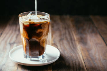 Nahaufnahme von Kaffee im Glas auf dem Tisch - EYF06446