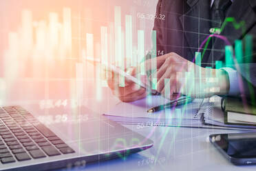 Doppelbelichtung eines Geschäftsmannes, der ein Telefon mit Diagrammen benutzt - EYF06447
