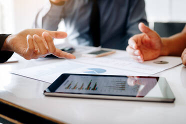 Cropped Image of Colleagues Working Over Graph In Office - EYF06464