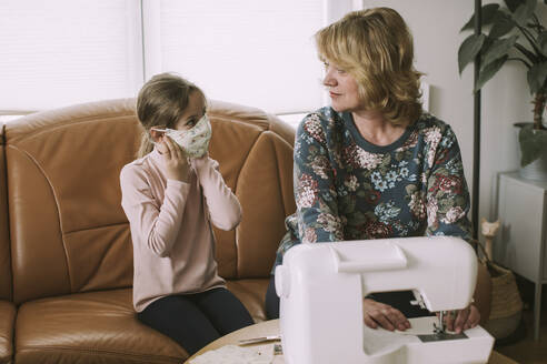 Ältere Frau betrachtet ihre Enkelin mit selbstgemachter Gesichtsmaske - VBF00094