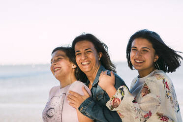 Happy mother enjoying with daughters against clear sky - DCRF00298