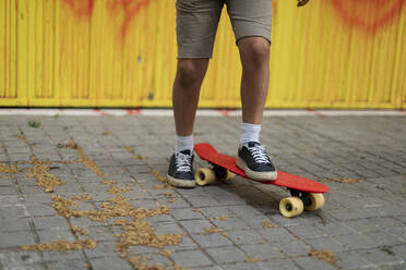 Beine eines Jungen, der auf dem Fußweg Skateboard fährt - VABF03073