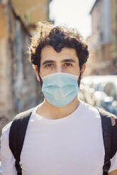 Portrait of young man wearing mask standing outdoors - MEUF00910