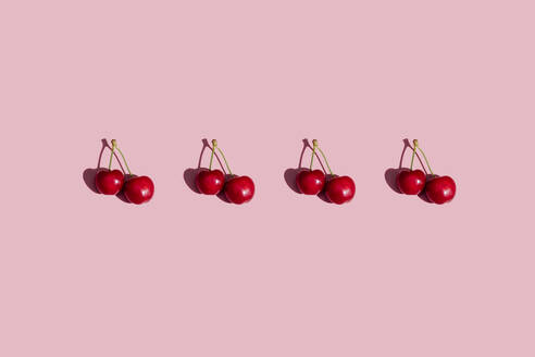 Reihe von frischen Kirschen auf rosa Hintergrund - GEMF03874