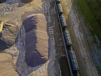 Russland, Tichwin, Luftaufnahme von Eisenbahnwaggons entlang einer Sandgrube in einem Asphaltwerk - KNTF04691