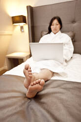 Geschäftsfrau benutzt Laptop im Hotelzimmer - CAVF85502