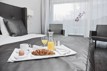 Frühstückstablett auf einem Bett in einem Luxushotelzimmer - CAVF85504