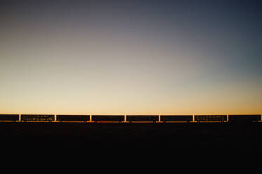 Silhouette Güterzug gegen klaren Himmel bei Sonnenuntergang - EYF06578