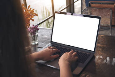 Midsection der Frau mit Laptop auf dem Tisch - EYF06580