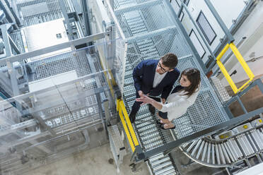 Manager diskutieren in der Fabrik stehend - DIGF12718