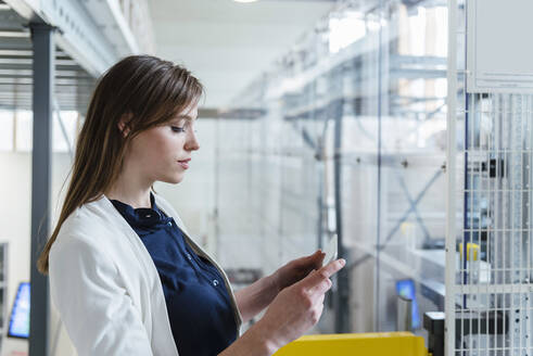 Close-up of businesswoman using digital tablet in factory - DIGF12719