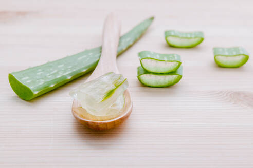 Nahaufnahme von Aloe Vera Gel mit Holzlöffel auf dem Tisch - EYF06607