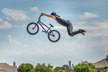 Low Angle View Of Man Performing Stunt On Bicycle Against Sky - EYF06631