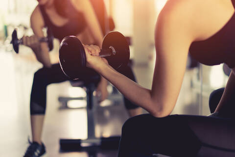 Young Woman in Sports Bra Holding Dumbbells on Bench Stock Image