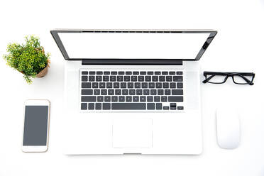 Directly Above View Of Laptop Amidst Mouse And Smart Phone On White Background - EYF06716