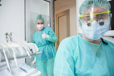 Dentist with nurse wearing scrubs working in hospital - JCMF00861