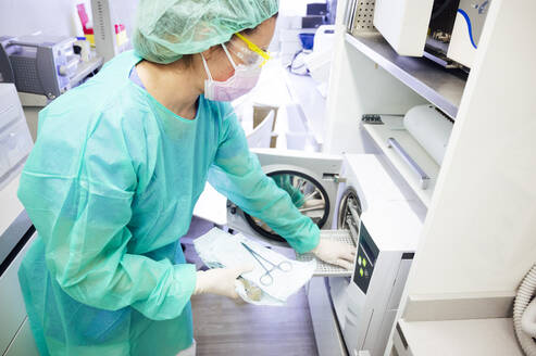 Zahnärztin sterilisiert medizinische Instrumente in der Klinik - JCMF00868