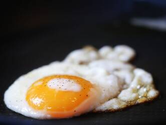 Close-Up Of Fried Egg Over Black Background - EYF06746