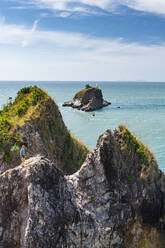 Woman on top of rocky outcrop, Mu Ko Lanta National Park, Koh Lanta, Thailand - RUNF03609