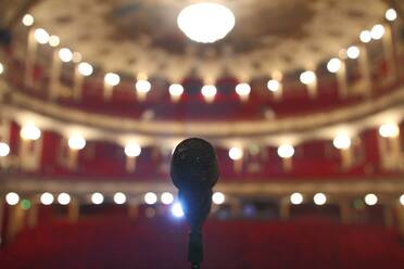 Nahaufnahme eines Mikrofons im beleuchteten Auditorium - EYF06829