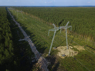 Russland, Oblast Leningrad, Tichwin, Luftaufnahme von Strommasten inmitten eines abgeholzten Gebiets - KNTF04694