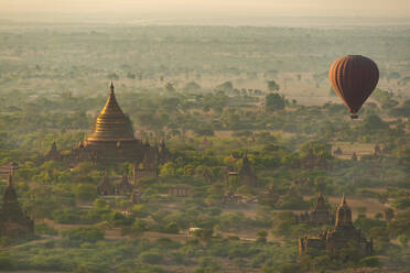 Myanmar, Mandalay Region, Bagan, Hot air balloon flying over Buddhist temples at dawn - TOVF00198